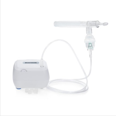Compact nebulizer machine with mouthpiece and tubing for respiratory treatment.