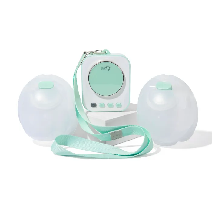 Portable breast pump with two collection bottles and strap in soft pastel green.