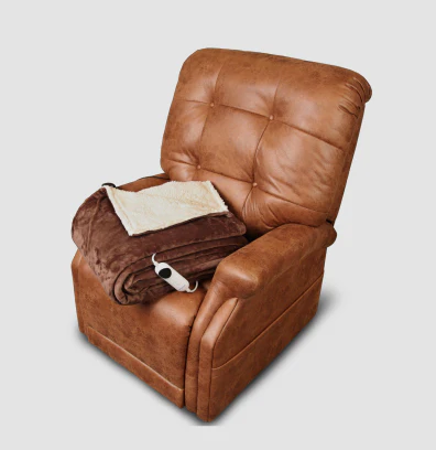 A brown leather recliner chair with a folded blanket and a remote control.